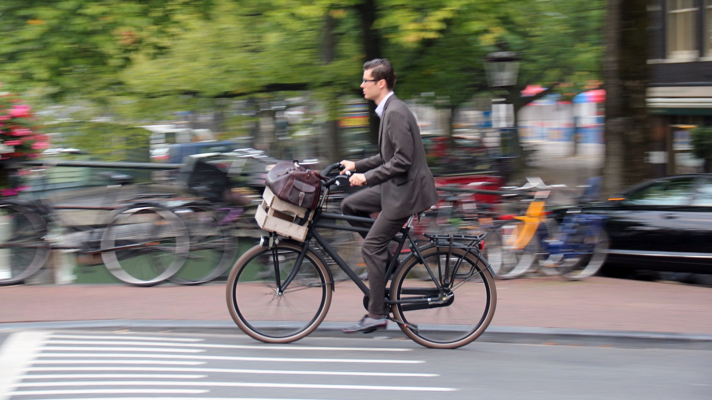 Man biking in a suit